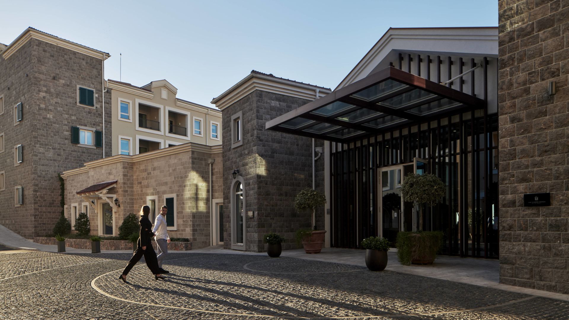 A Person Walking In A Courtyard Between Buildings