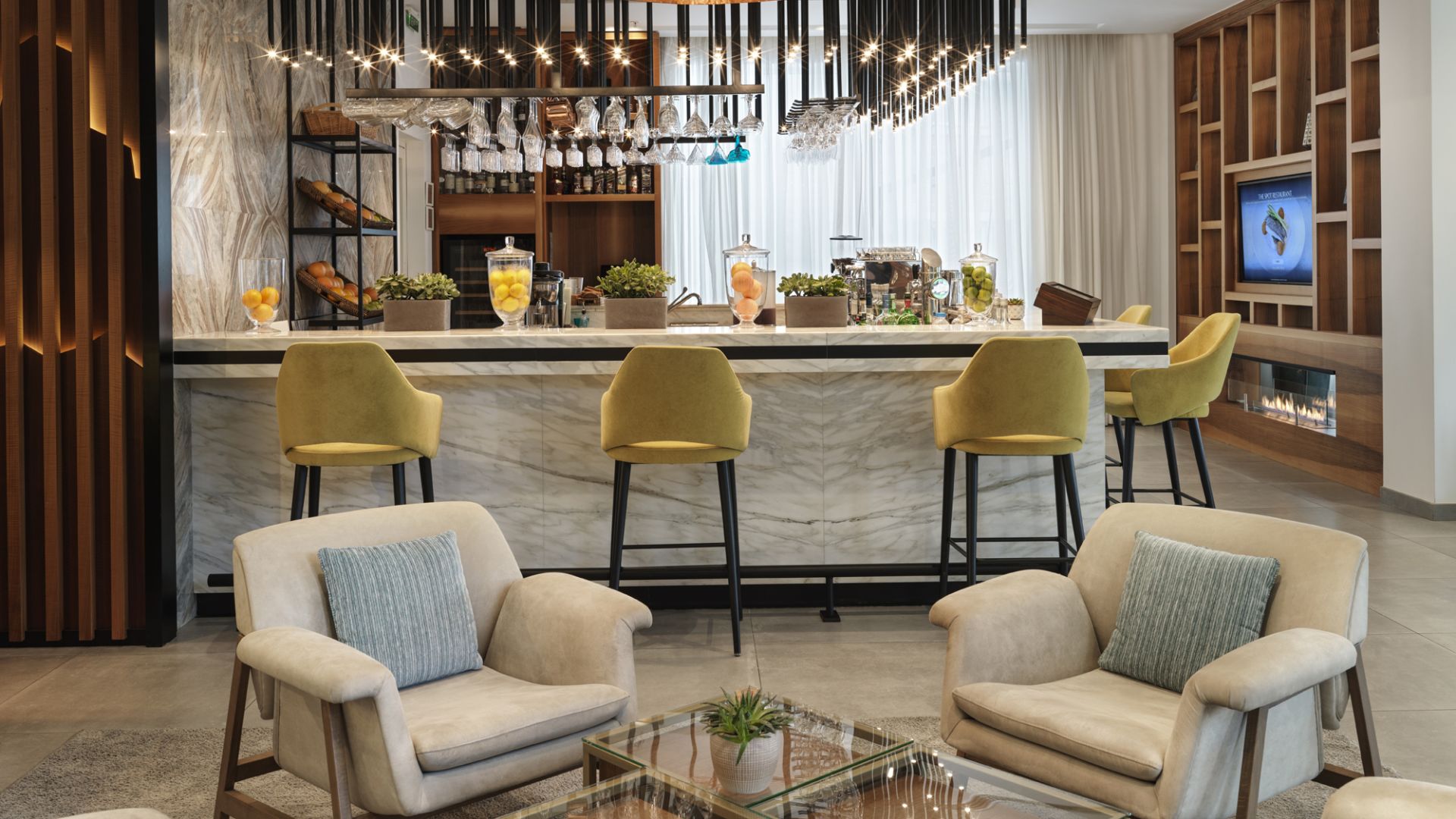 A Bar With A Large Chandelier And Chairs