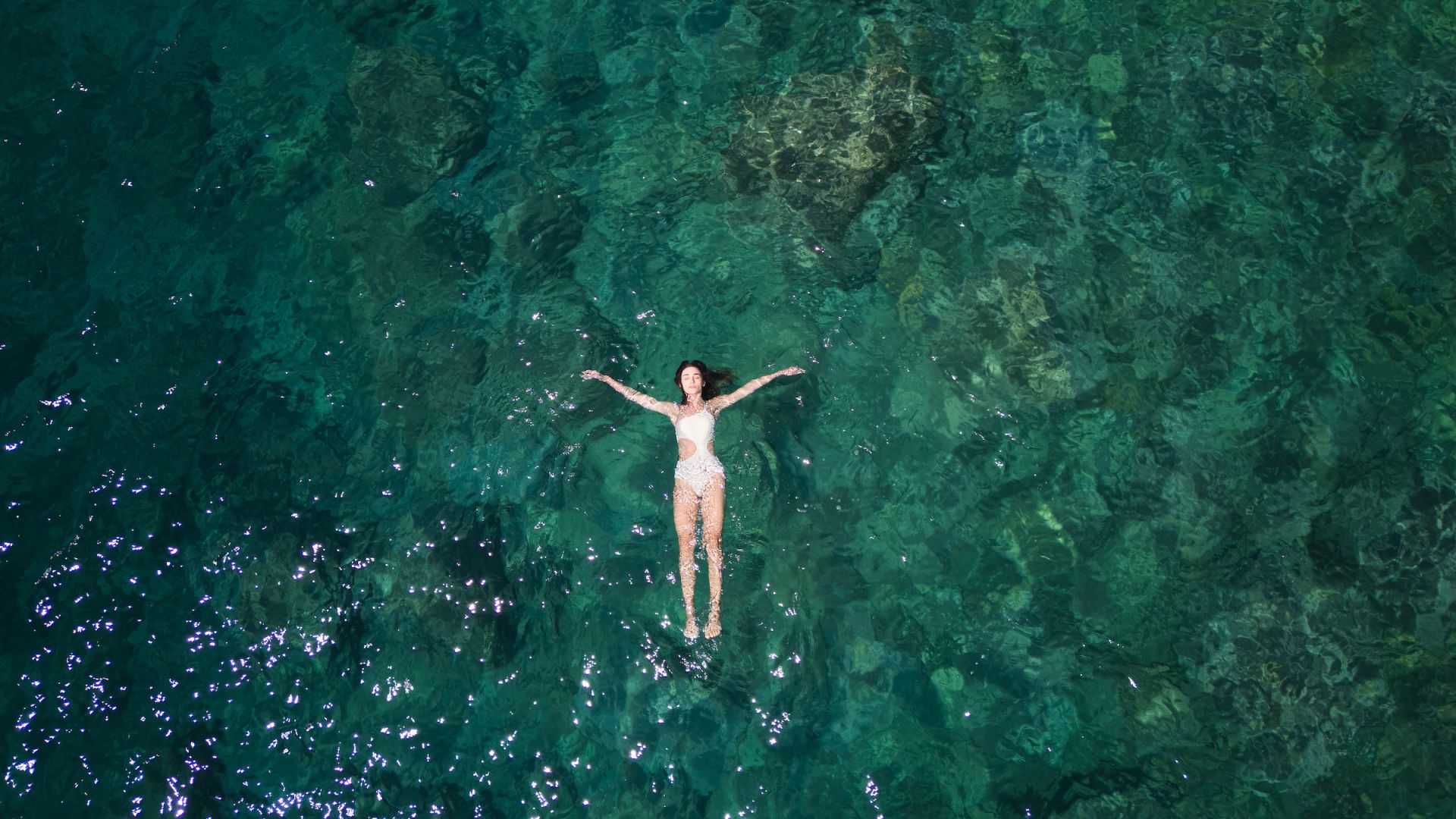 A Person In A White Dress Surrounded By Water